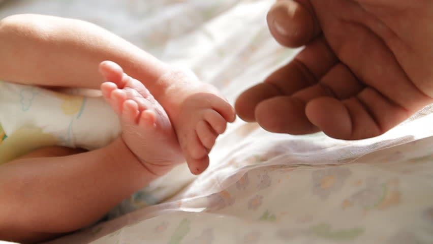 Touching newborn baby's feet