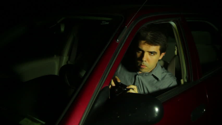 Private investigator taking photos at night.