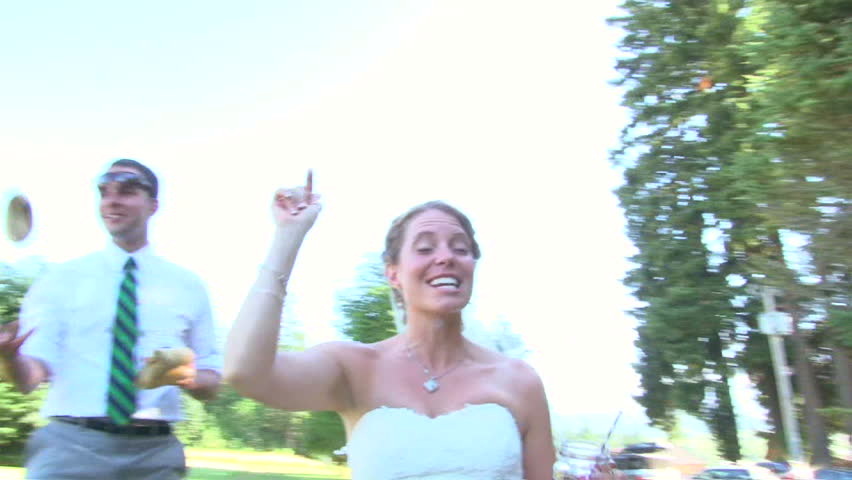 Model released bride and groom play bean bag lawn game together on their wedding day.