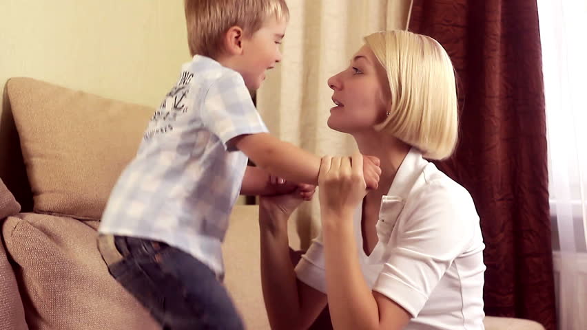 Mother playing with her baby boy at home