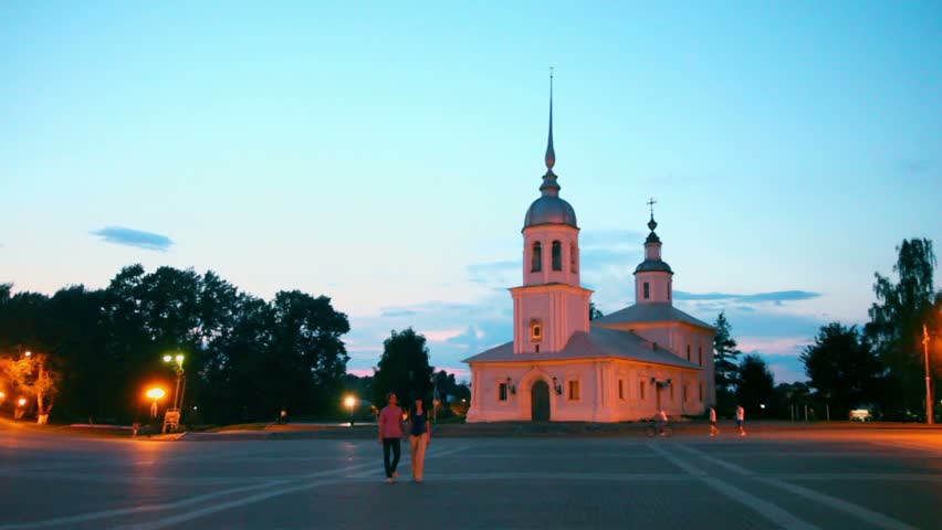 Couple approach by Kremlin square in morning with Alexander Nevsky Church in Vologda, Russia