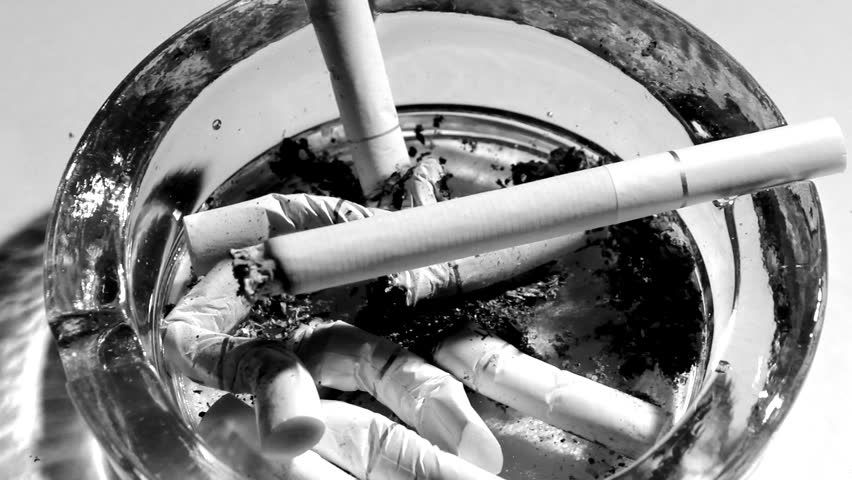 A burning cigarette in an ashtray -time lapse - black and white