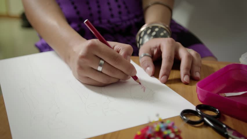 Female fashion designers drawing sketches for clothes in atelier. Sequence