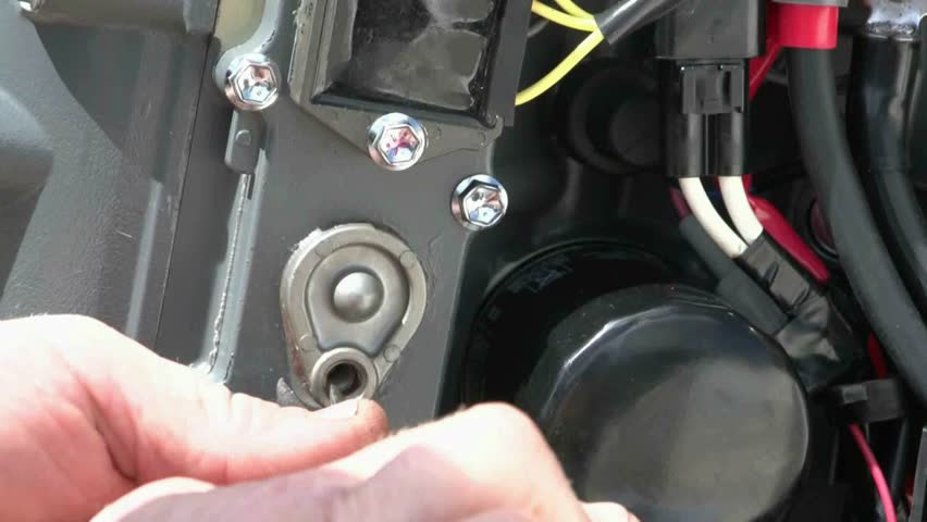Mechanic removes a sacrificial anode from outboard motor, checks for corrosion or salt build up.