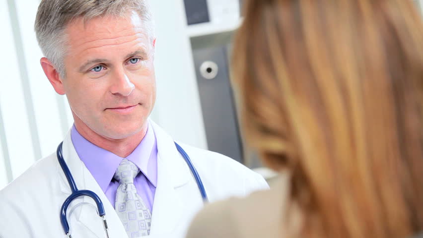 Full frame female pharmaceutical representative meeting doctor responsible for clinical trials in his practice rooms