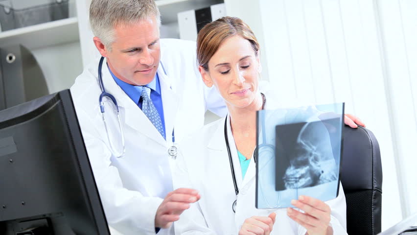 Caucasian hospital doctors checking patients x-ray results