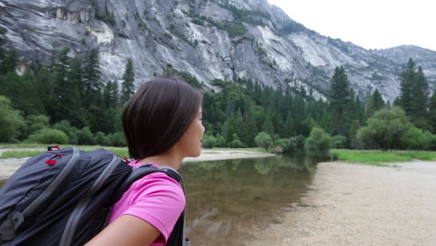 Hiking woman on hike in yosemite national park. Back  view of woman hiker in motion.