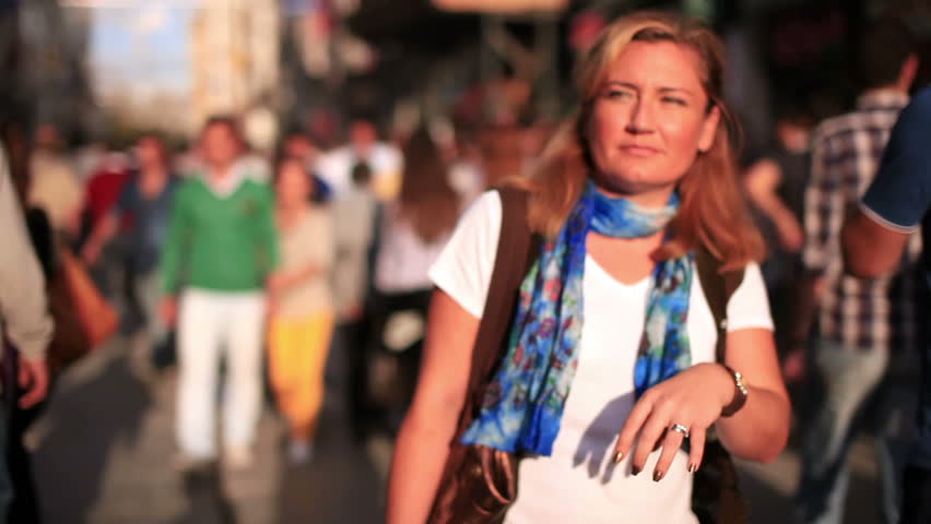 woman walking on the very crowded street, stabilized camera