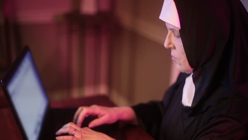 nun typing on the computer