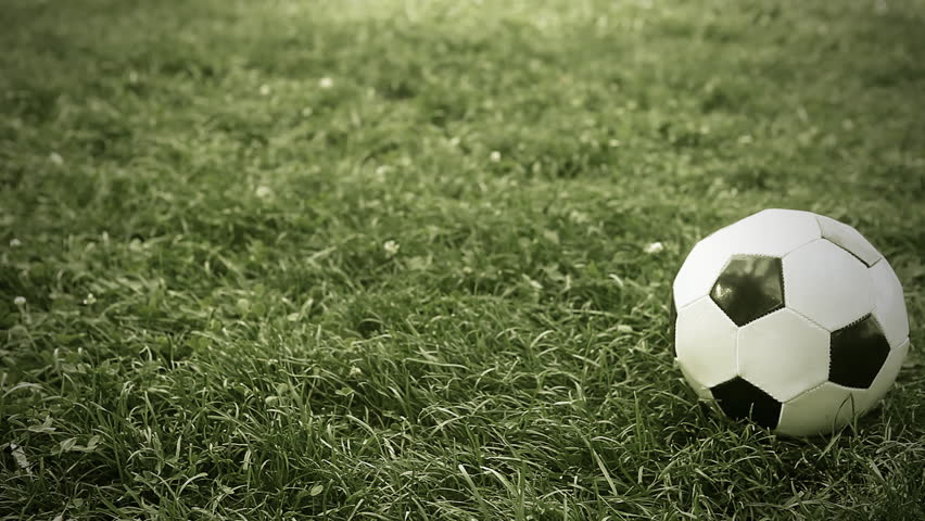 Soccer ball on the grass of football field