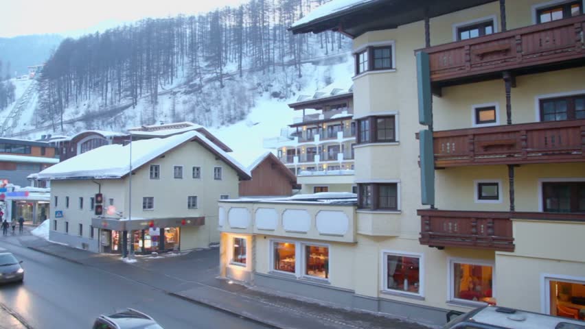 Traffic at street in small town near mountain with forest on winter day