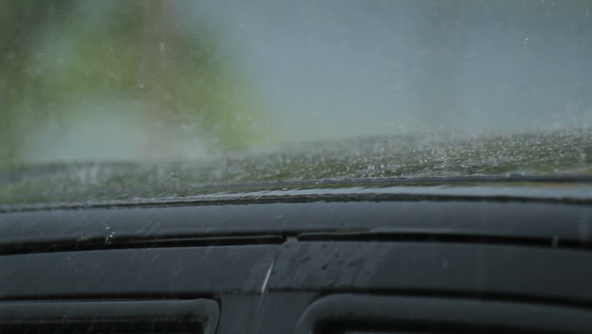 heavy rain falling on car roof