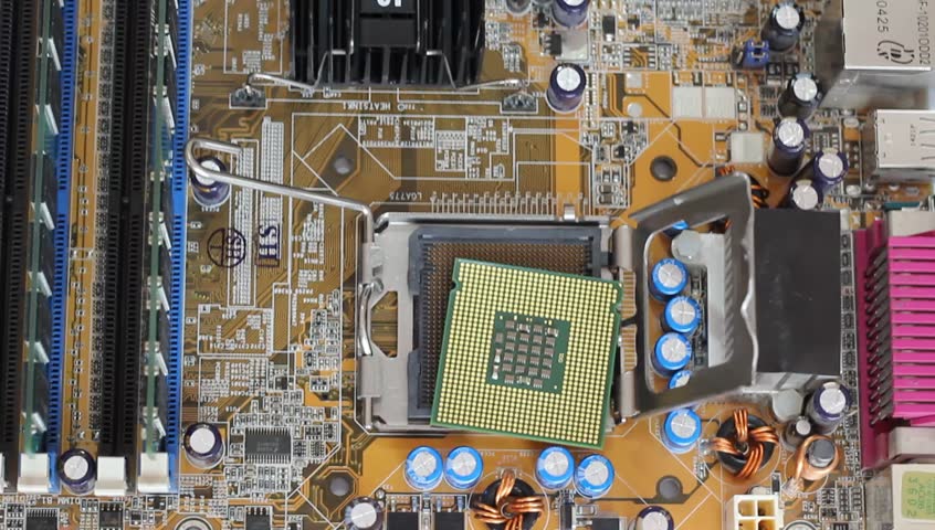 Man pulls out a computer processor from the motherboard. 