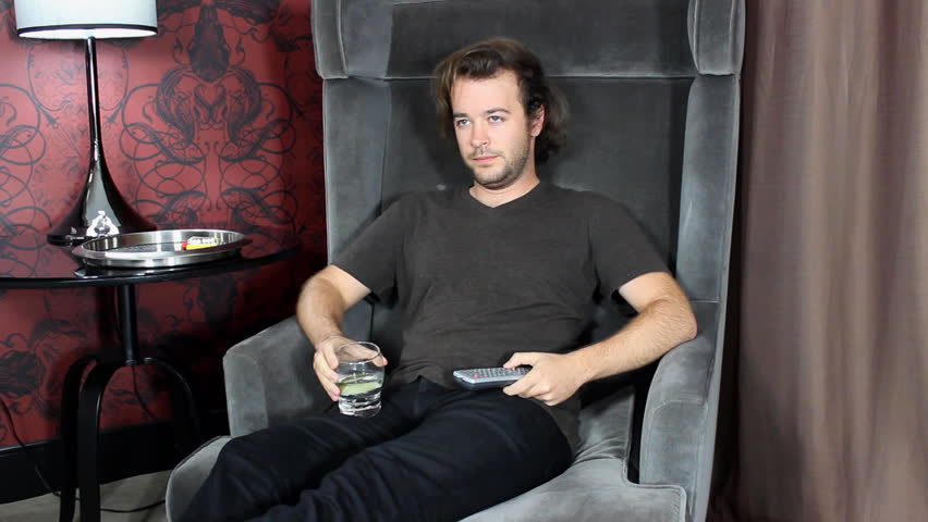 Man with remote watches TV