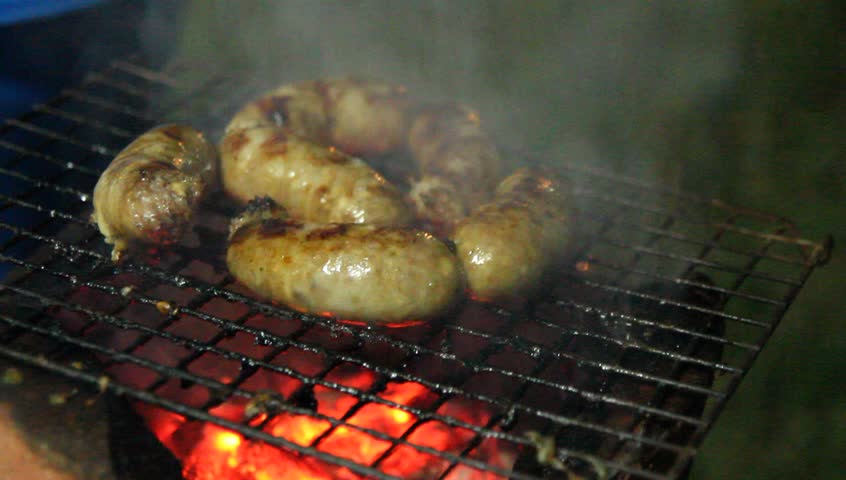 Sausages roasting on the garden grill