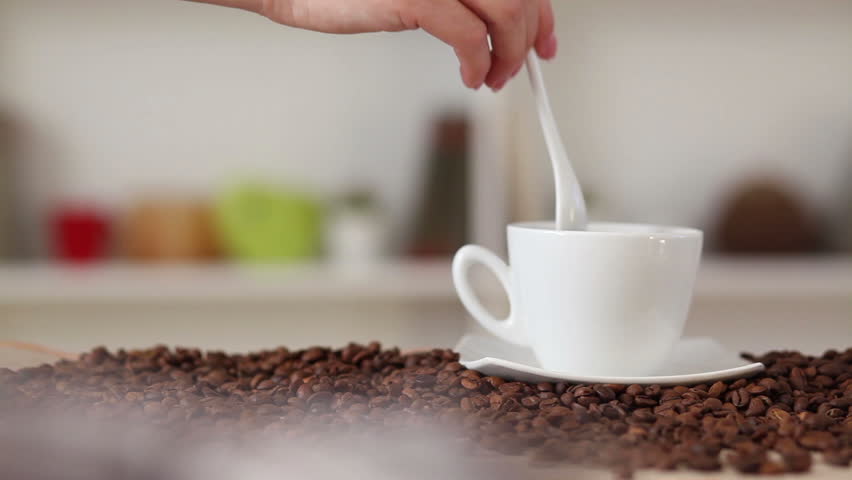 A woman's hand stirring coffee