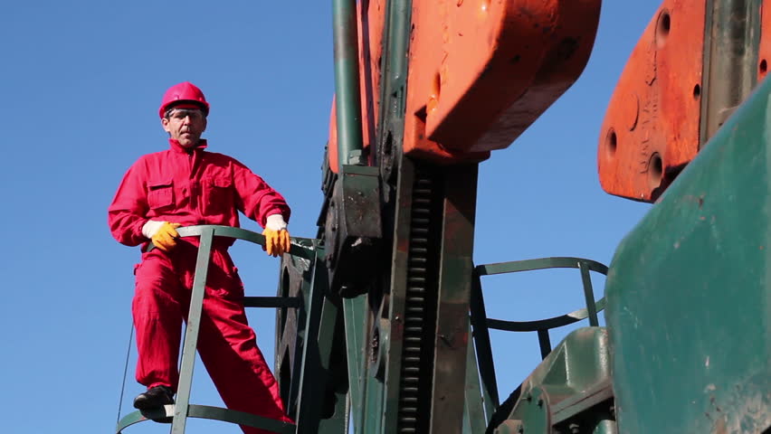 Oil Worker and Pump Jack.
Worker in action at pump jack oil well. HD1080p. 
