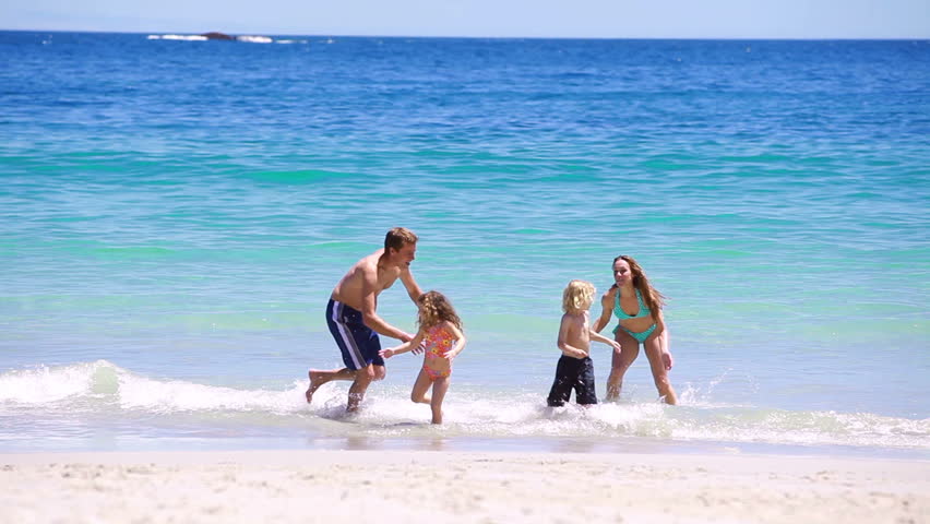 Happy family splashing each other on the beach