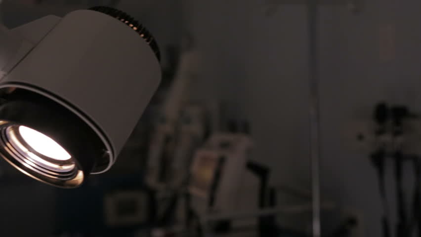 Detail of surgical lamp lit in empty operating room