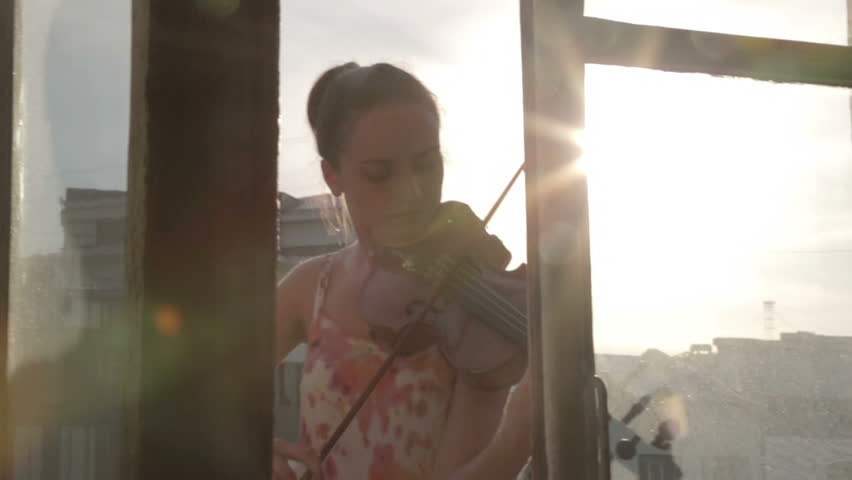 Girl playing violin on the balcony