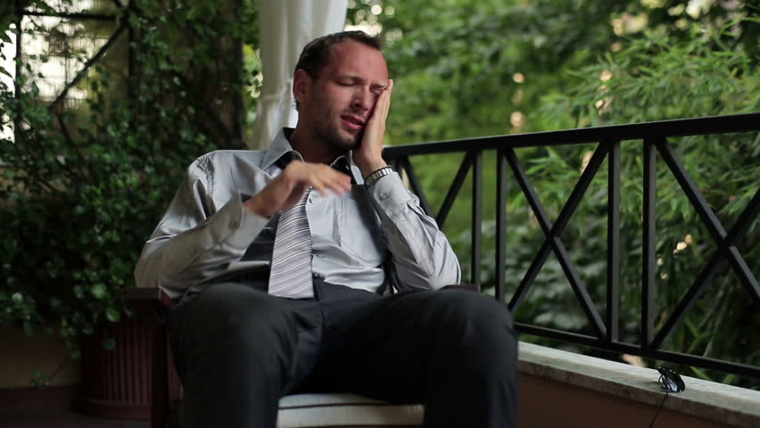 Young tired, frustrated businessman resting on balcony
