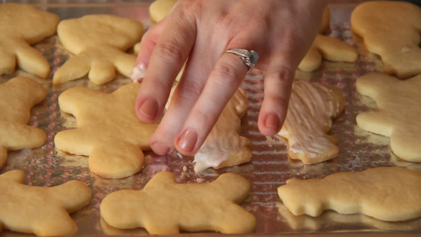 Baking Sugar Cookies 18. Preparing, mixing, baking and decorating Christmas sugar cookies. Brushing icing to the tops of the cookies.