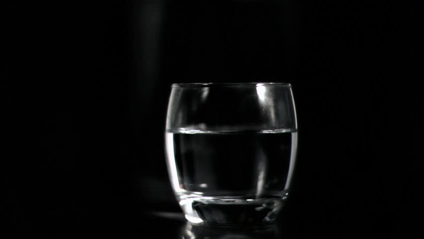 Vodka splashing in super slow motion against black background