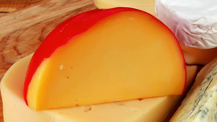 dairy food different cheeses served on wooding cutting board
