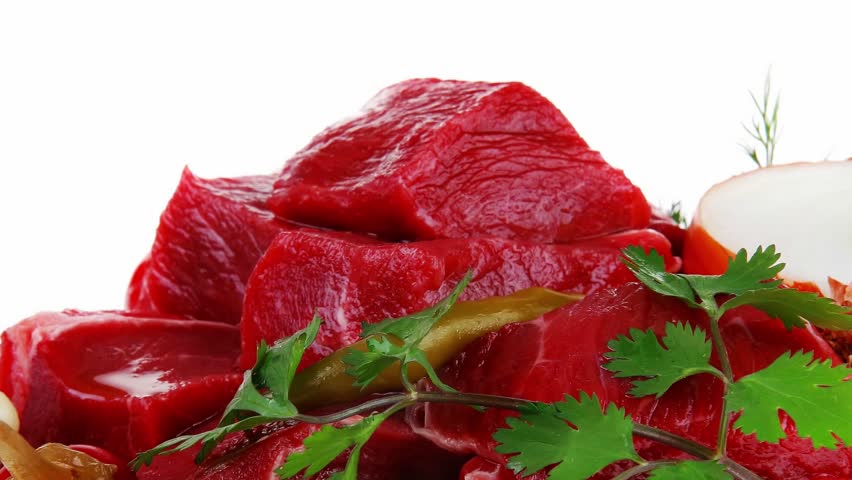 fresh uncooked beef meat slices over white bowls ready to prepare with red peppers and greenery isolated over white background