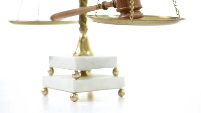 Vertical pan of a gavel resting on scales of justice.