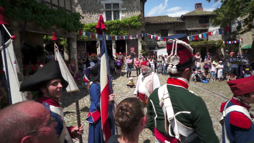 PEROUGES, FRANCE - JULY 14, 2012: French Revolution historic commemoration, with folks wearing the common clothes of that time and singing the popular songs of their ancestors