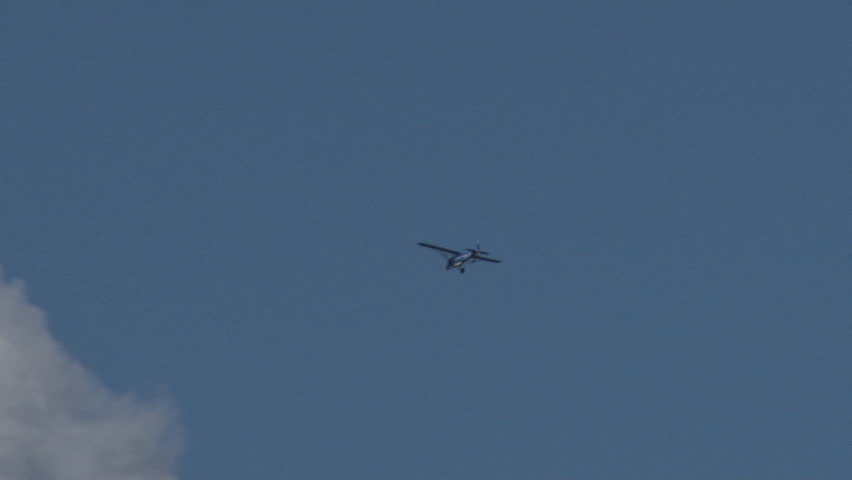Small private plane of the high wing type barrels headfirst into a massive cumulus cloud formation