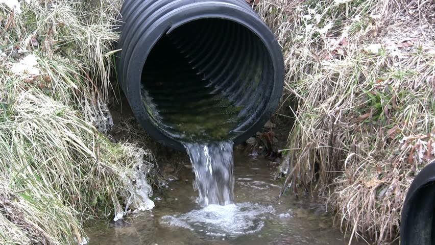 Water draining from one plastic pipe