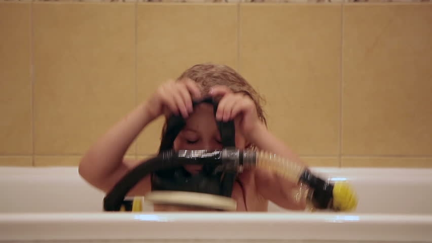 Small Caucasian girl in bath playing with mask and snorkel diving. Edited sequence. 