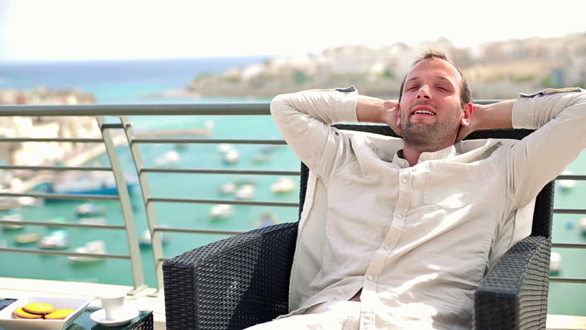 Young happy man relaxing on beautiful terrace
