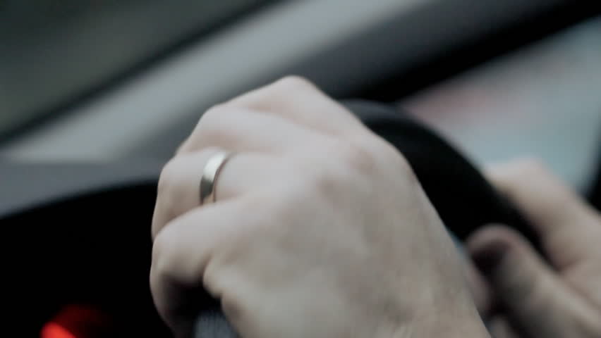 Hands drumming on steering wheel
