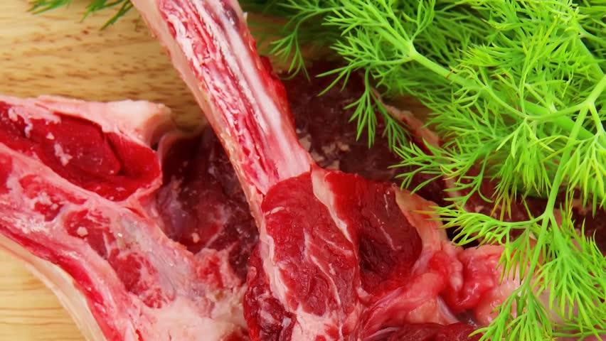 raw meat : boned fresh ribs served with dill and green chives on wooden board isolated over white background