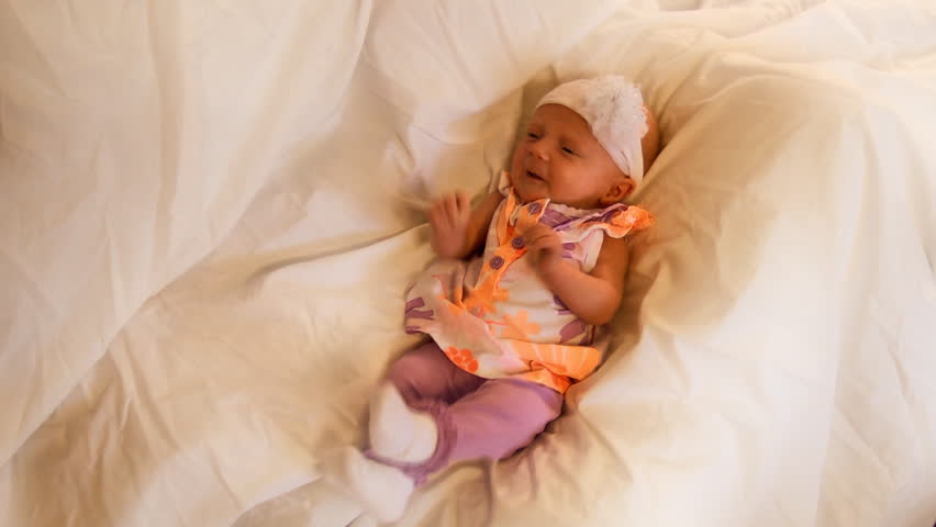 A beautiful one month old baby girl cries for attention