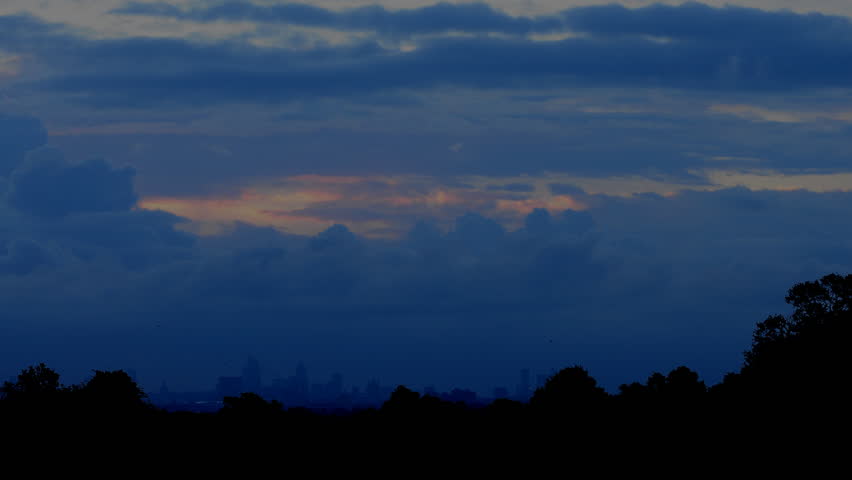 Sunrise over London. Time lapse of London at dawn filmed from Richmond Park. Dramatic clouds silhouette the skyline.
