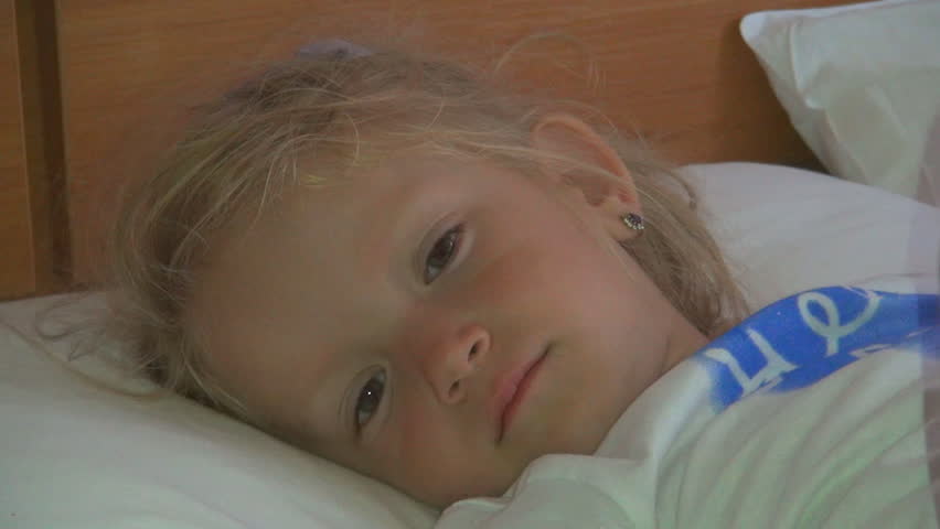 Little Girl Lying in Bed after a Nap, Sleepy Child Looking at Camera