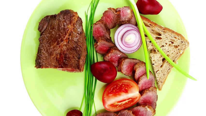 main course : roast red meat slices served on green plate with tomatoes and sprouts isolated on white background