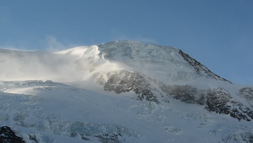 Strong wind over glacial mountain ridge of Alphubel mountain peak, Saas Fee, Valais, Switzerland