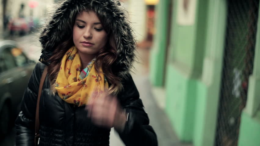 Pensive young woman walking in the city, steadicam shot