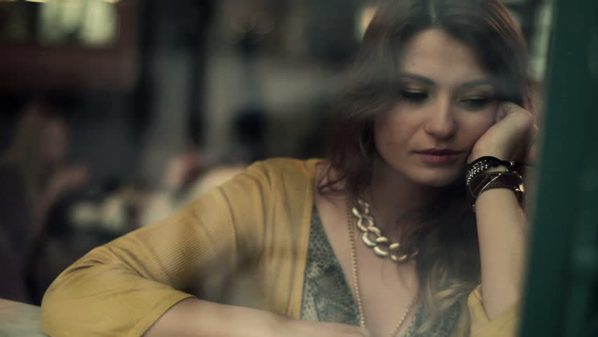 Sad, depressed young woman sitting in cafe, steadicam shot