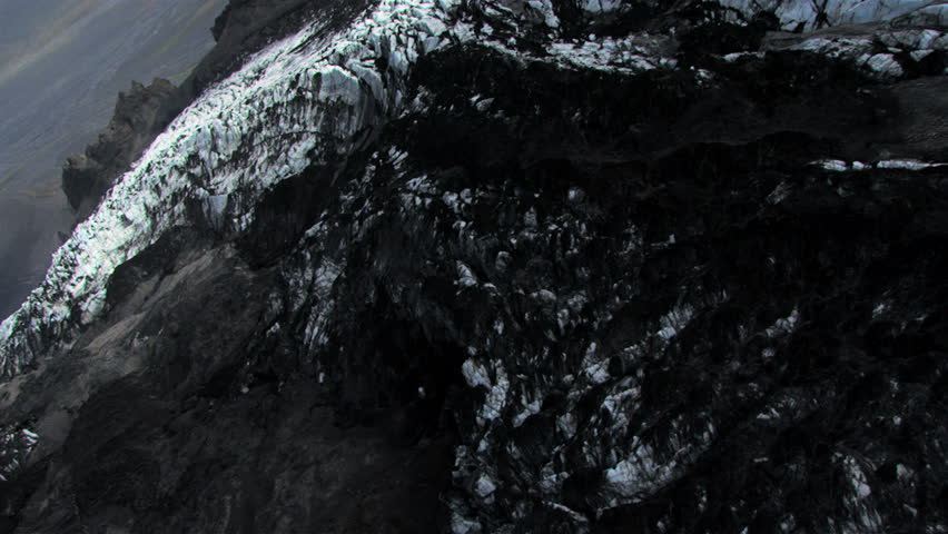 Aerial view of sedimentary layers of Volcanic dust deposited across an Icelandic glacier after a Volcanic eruption, Iceland