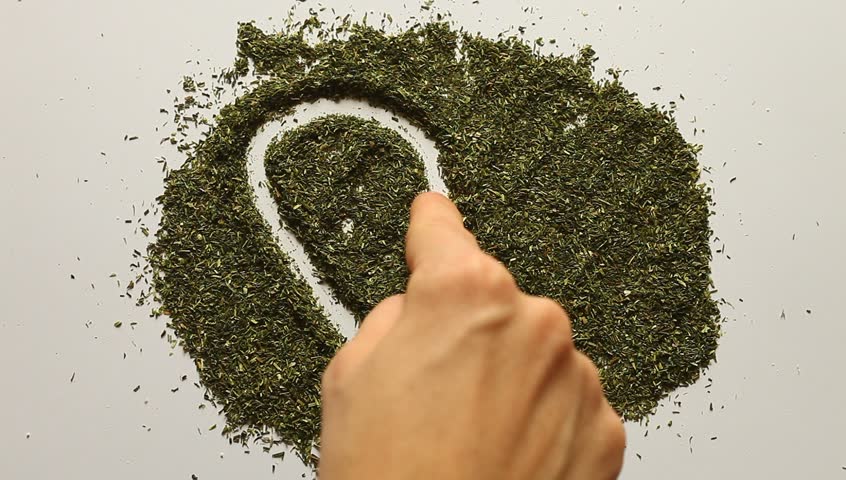 Young adult woman makes Valentines heart out of dry dill.
