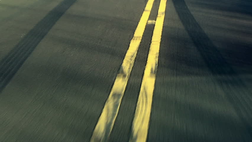 skidmarks cover the yellow lines in the road