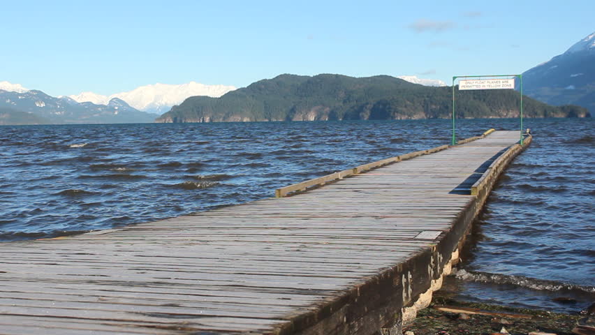A long, narrow dock leads into Harrison Lake in British Columbia's Fraser Valley/Dockside at Harrison Lake/Winter on Harrison Lake in British Columbia's Fraser Valley. 