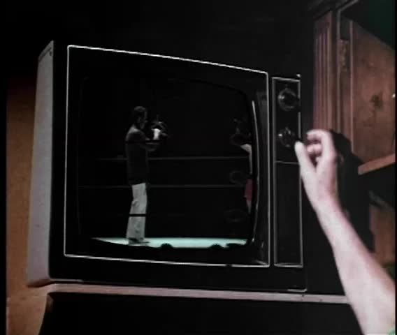 Person turning off 1970s TV set