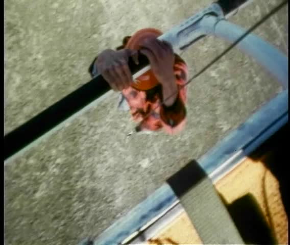 Stuntman hanging from landing gear of helicopter
